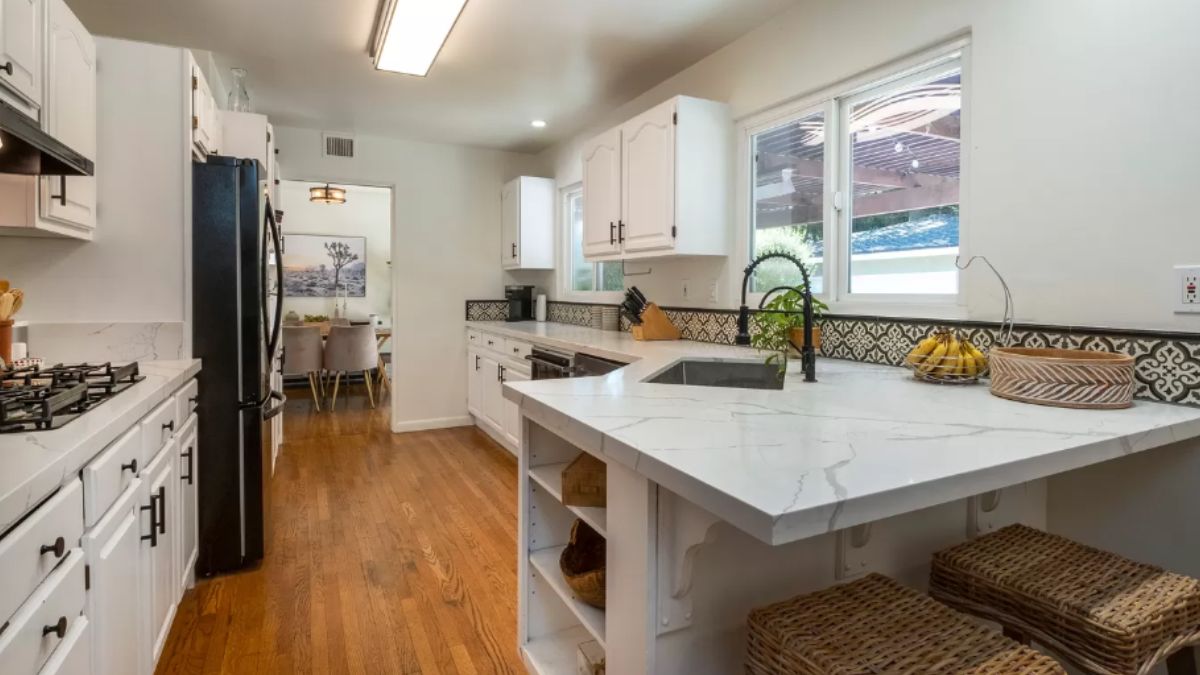 A kitchen with countertops, a sink, cabinets, and kitchen appliances.