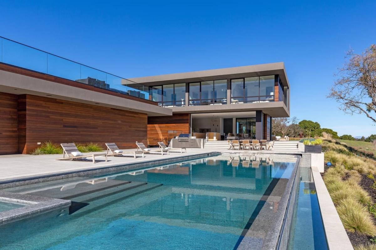 Pool with lounge chairs and a dining area.