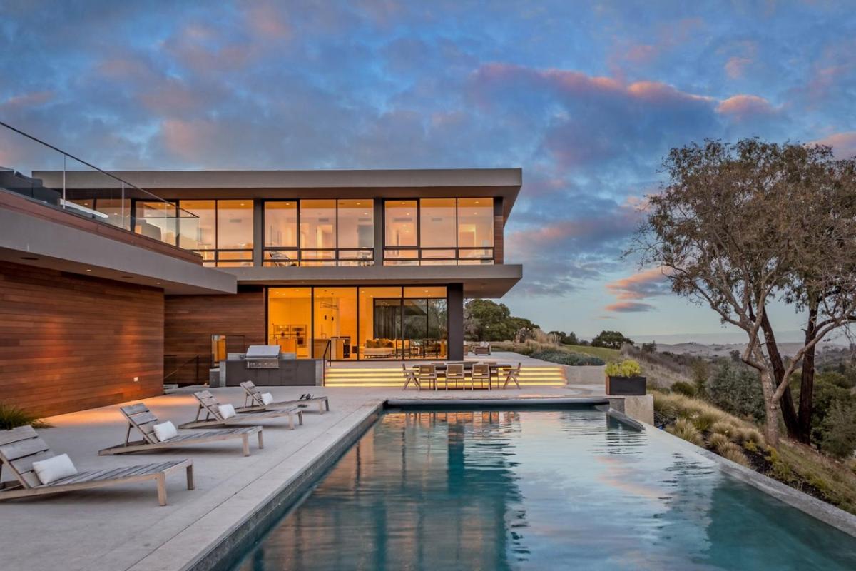 Pool with lounge chairs and a dining area.