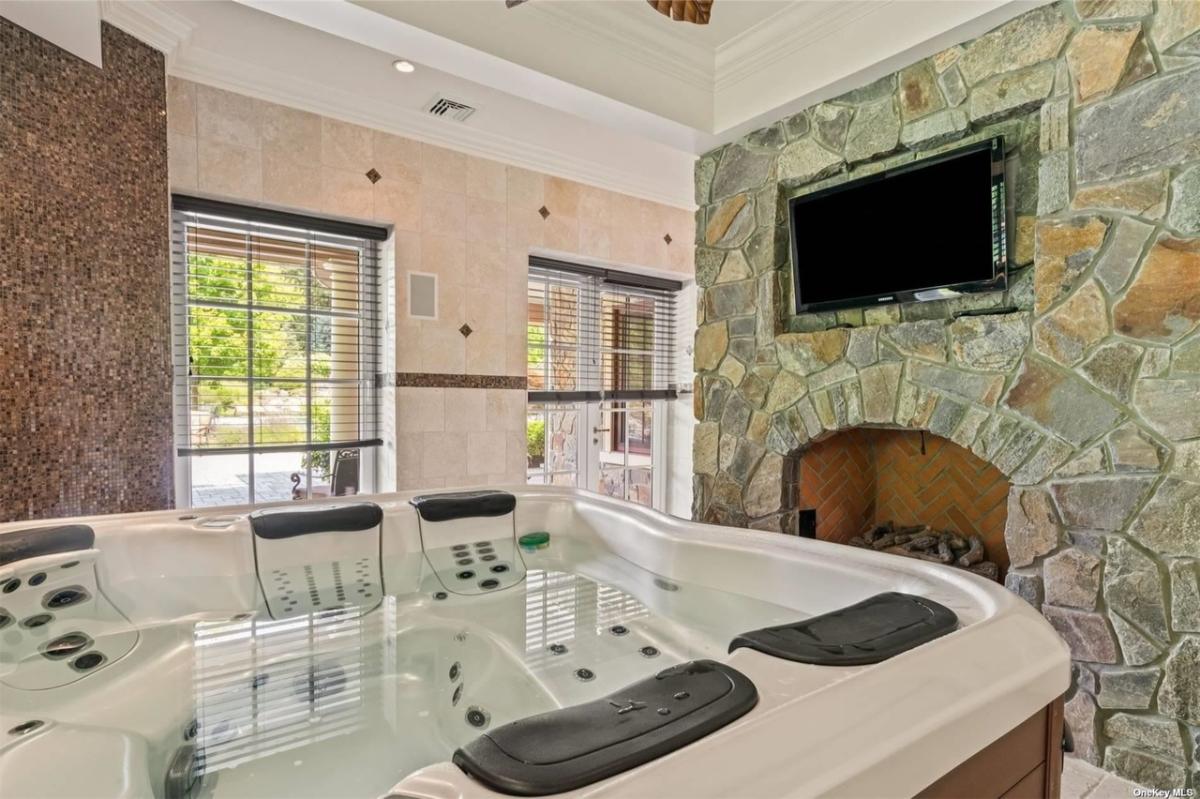 Hot tub with a TV and a fireplace.