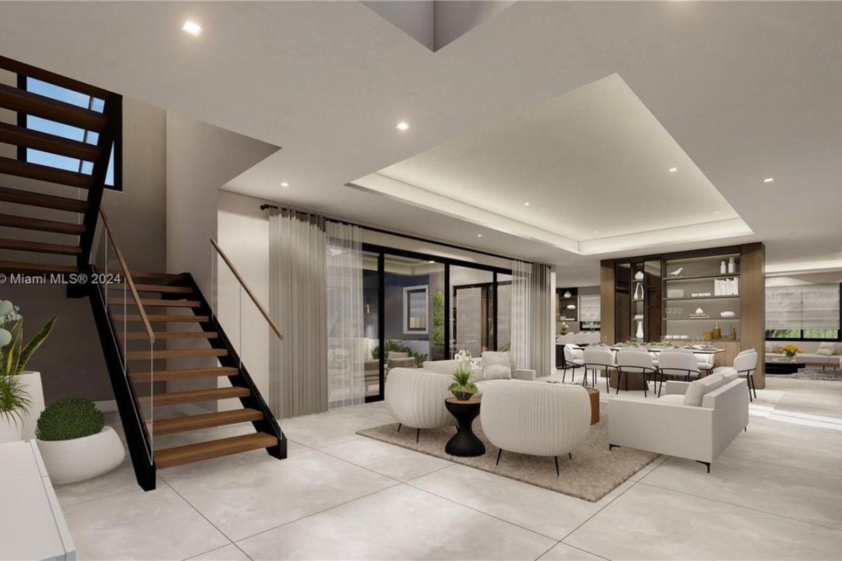 A living room with a rug, white couches, white chairs, and a center table.