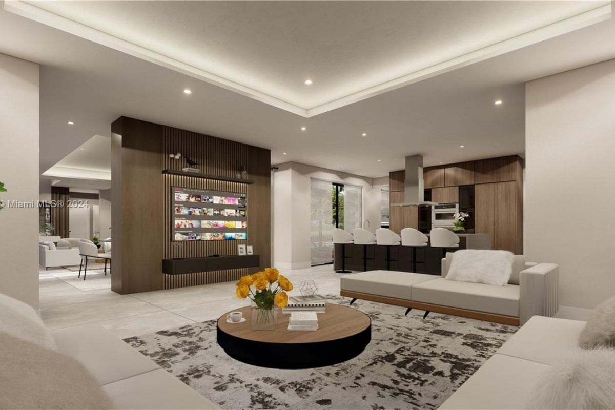 A living room with white couches, a rug, and a round center table.