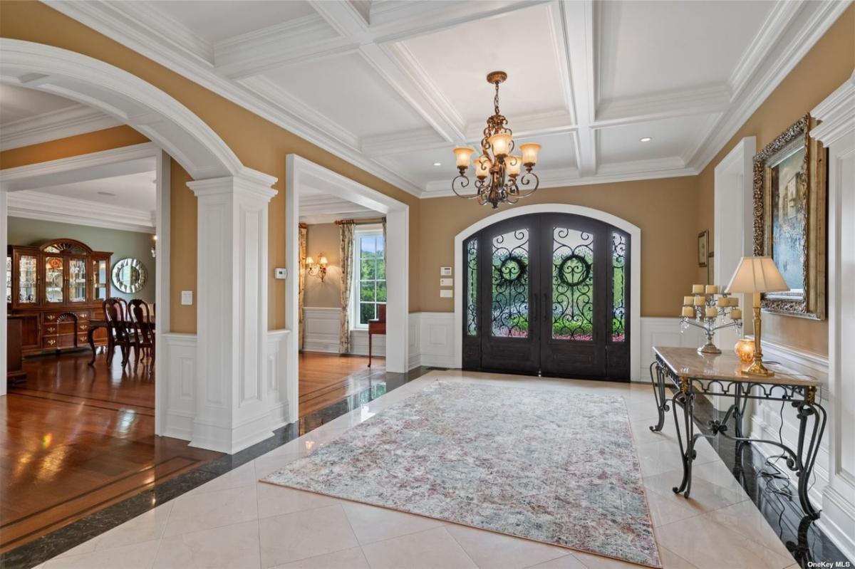 Foyer with coffered ceilings and a chandelier.