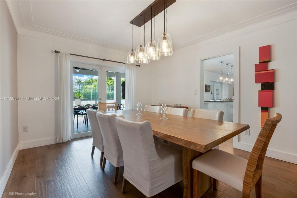 A dining room with a dining table surrounded by chairs.