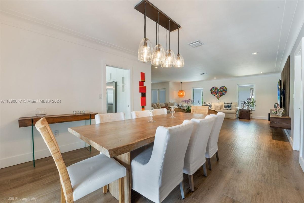 A dining room with a dining table surrounded by chairs.