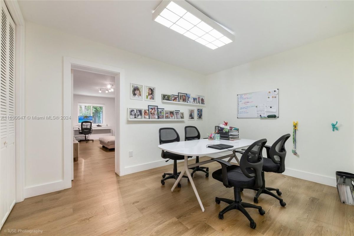 A conference room with a table surrounded by office chairs.