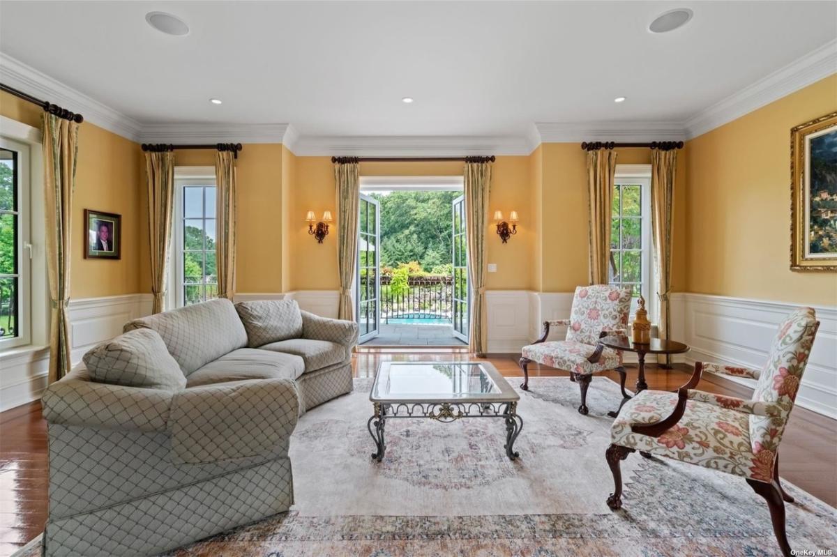 Living room with couches and hardwood floors.