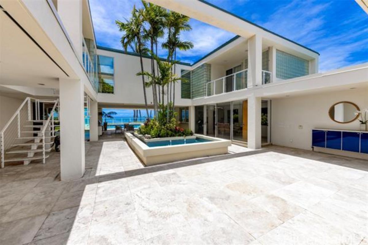 A courtyard with a pool and plants in the center.