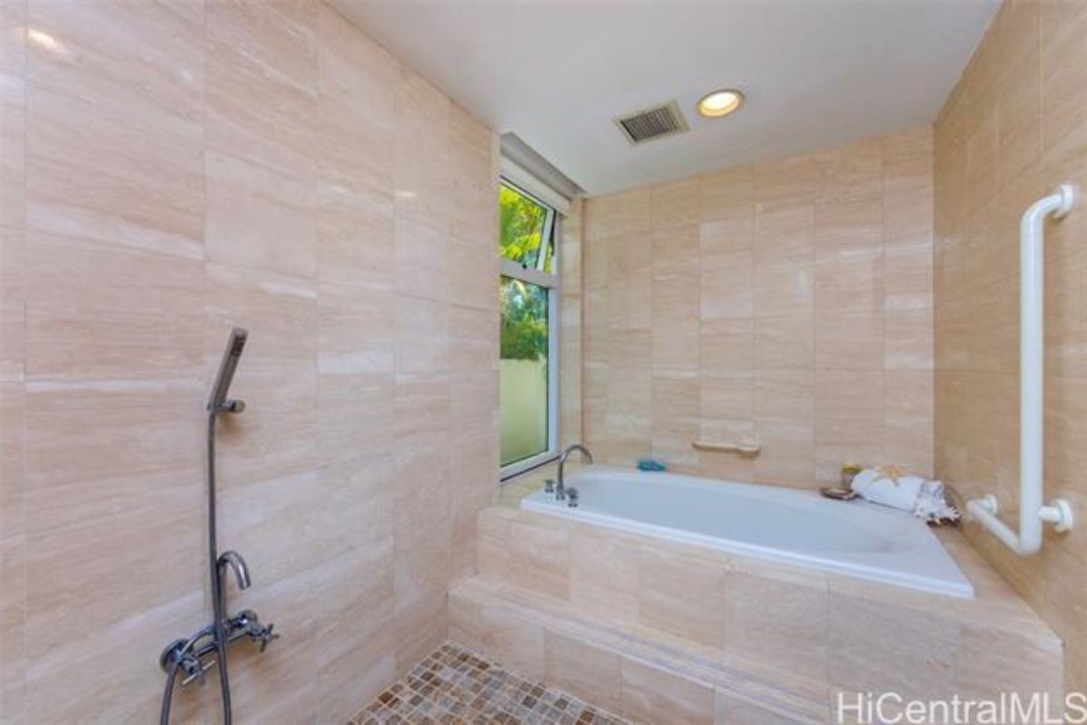 A bathroom with a window, shower, and bathtub.