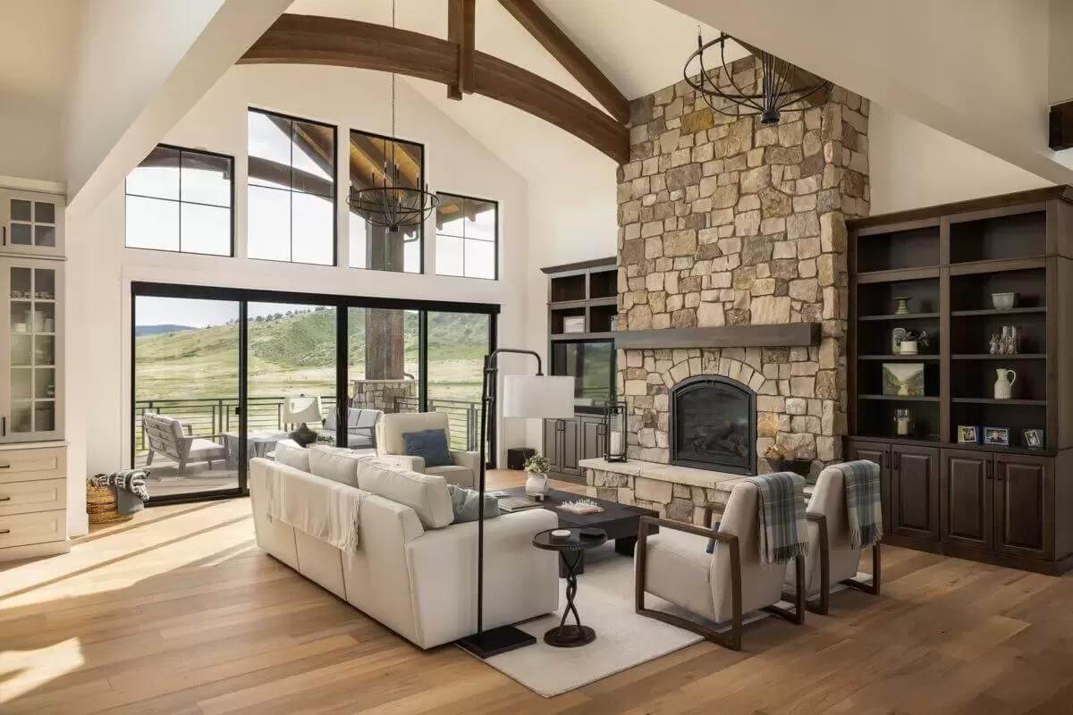 Great room with gray sofas and a stone fireplace flanked by dark wood built-ins.