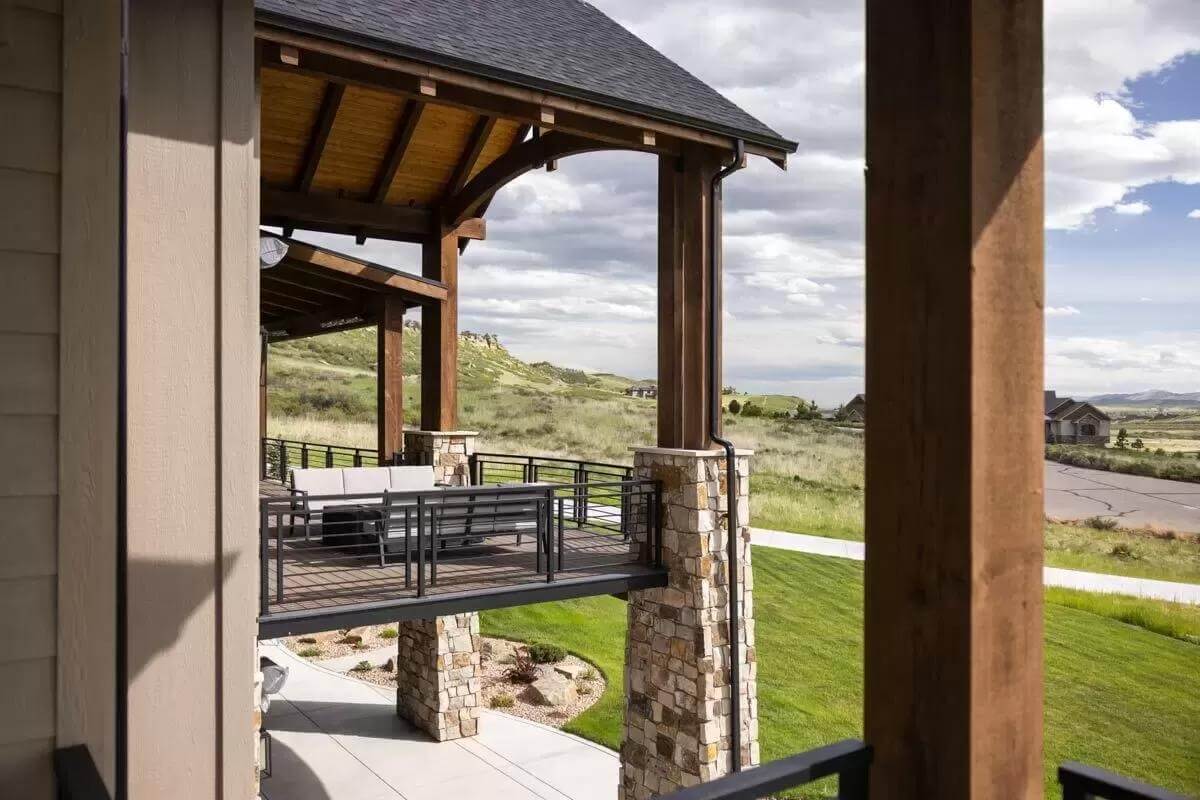 Covered deck with sectional sofas under a cathedral ceiling.