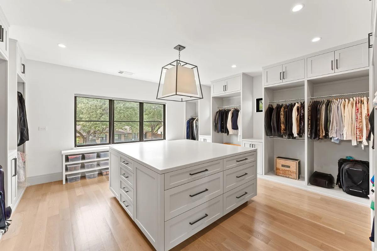 Walk-in closet with glass windows and hardwood floors.