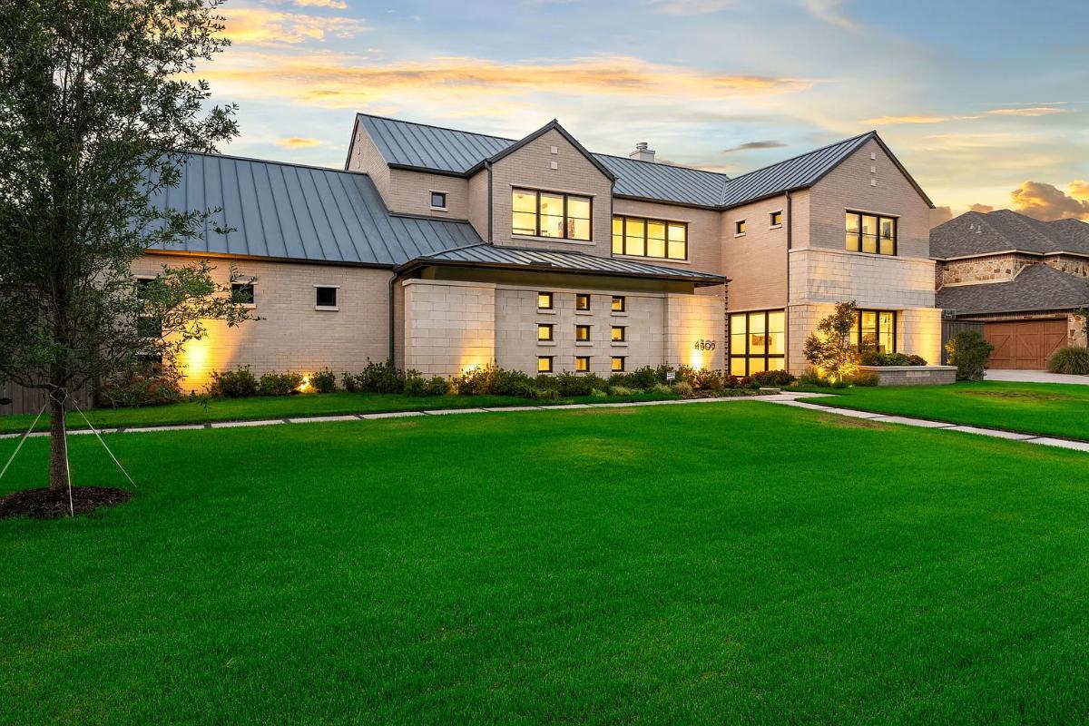 Front view of the mansion with a large green lawn.