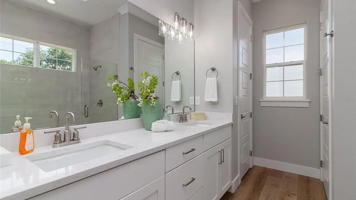 A bathroom with a vanity, mirror, and cabinet.