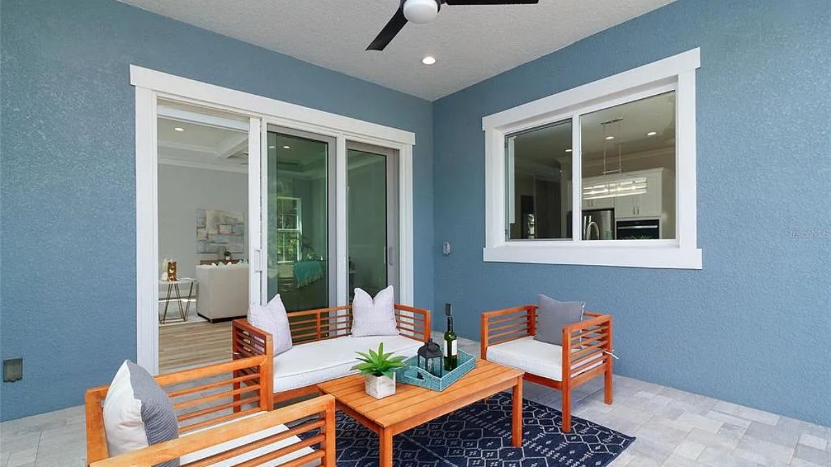 A lanai with a ceiling fan, couch, chairs, and a center table.