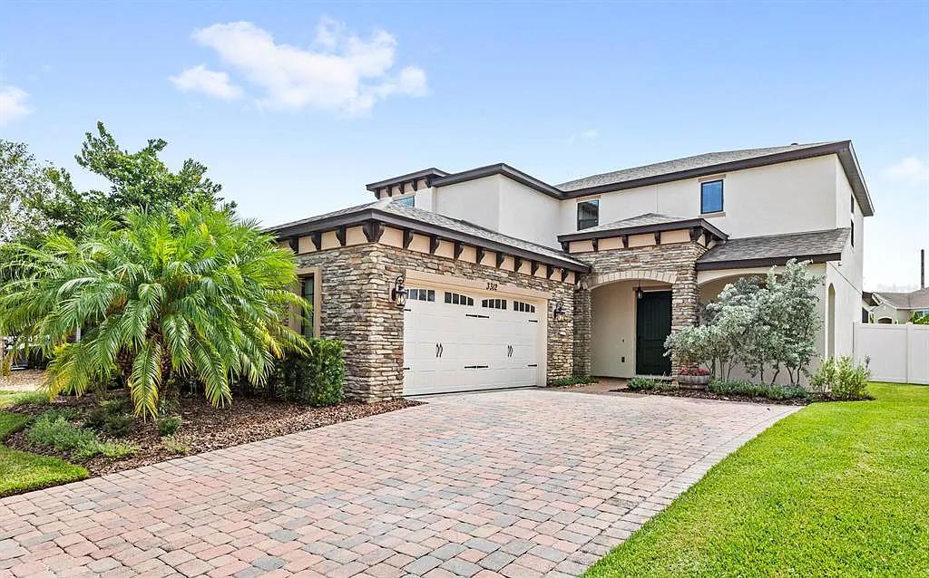 Stone Accents and a Brick Driveway Define This Contemporary Home