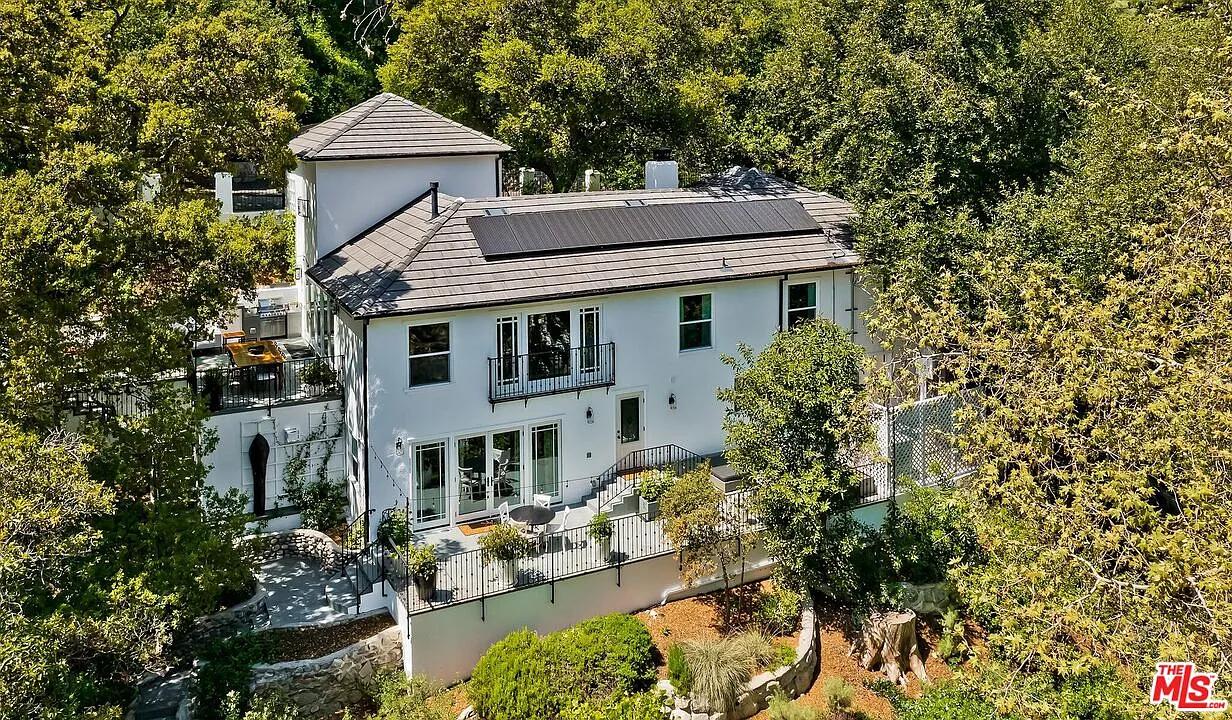 Elegant Two-Story Home with Solar Panels and Lush Surroundings