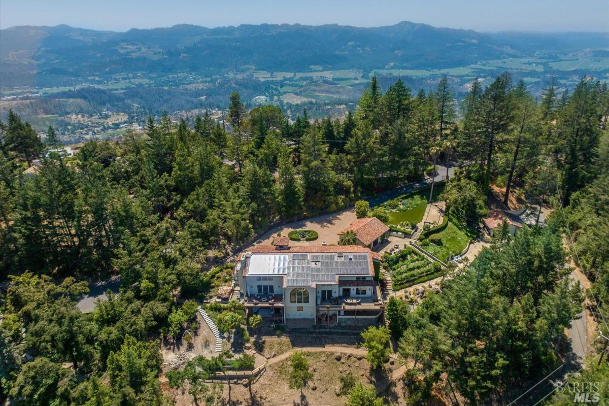 Aerial view of a large estate surrounded by trees and hills.