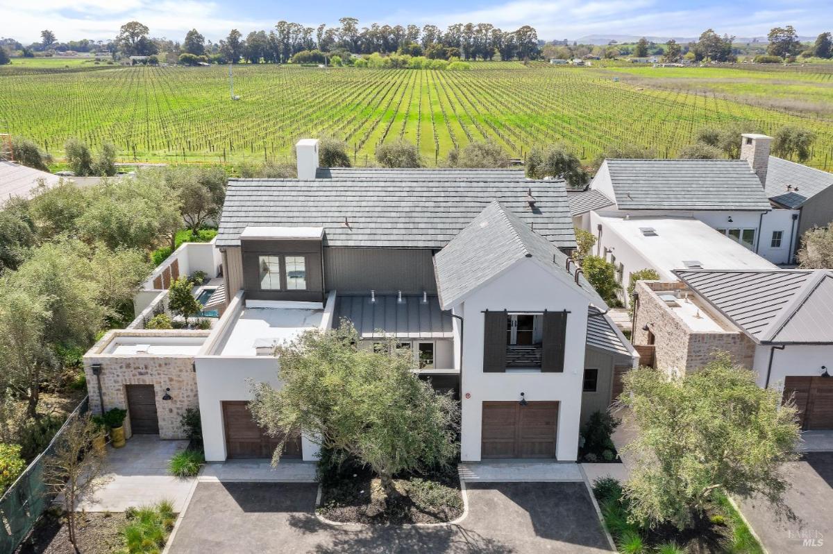 Aerial view of a house with a vineyard in the background.