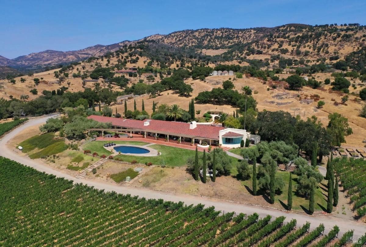 An overhead image showing a vineyard estate with a pool and surrounding hills.