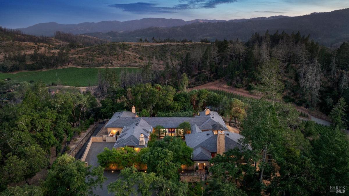 Aerial view of a large estate surrounded by hills and trees.