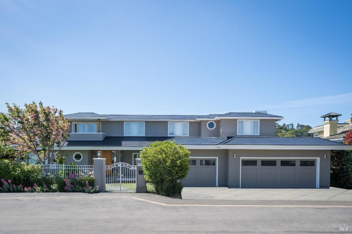 A two-story house with a gated front yard and three-car garage.