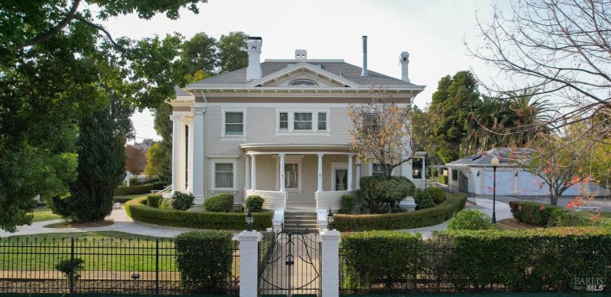 Front view of a white two-story home with a fenced yard.