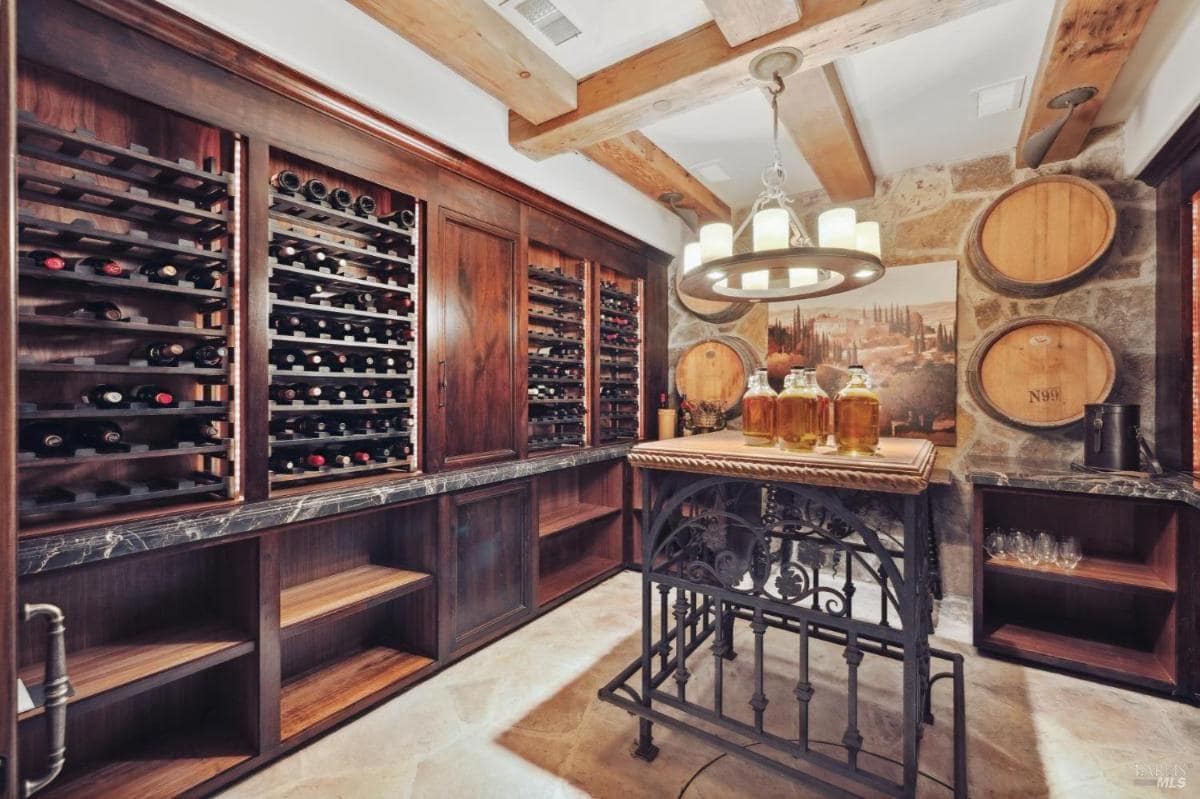 A wine cellar with wood racks, barrels, and a central display table.