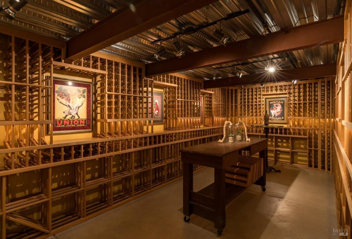 Wine cellar with wood racks and an island table.