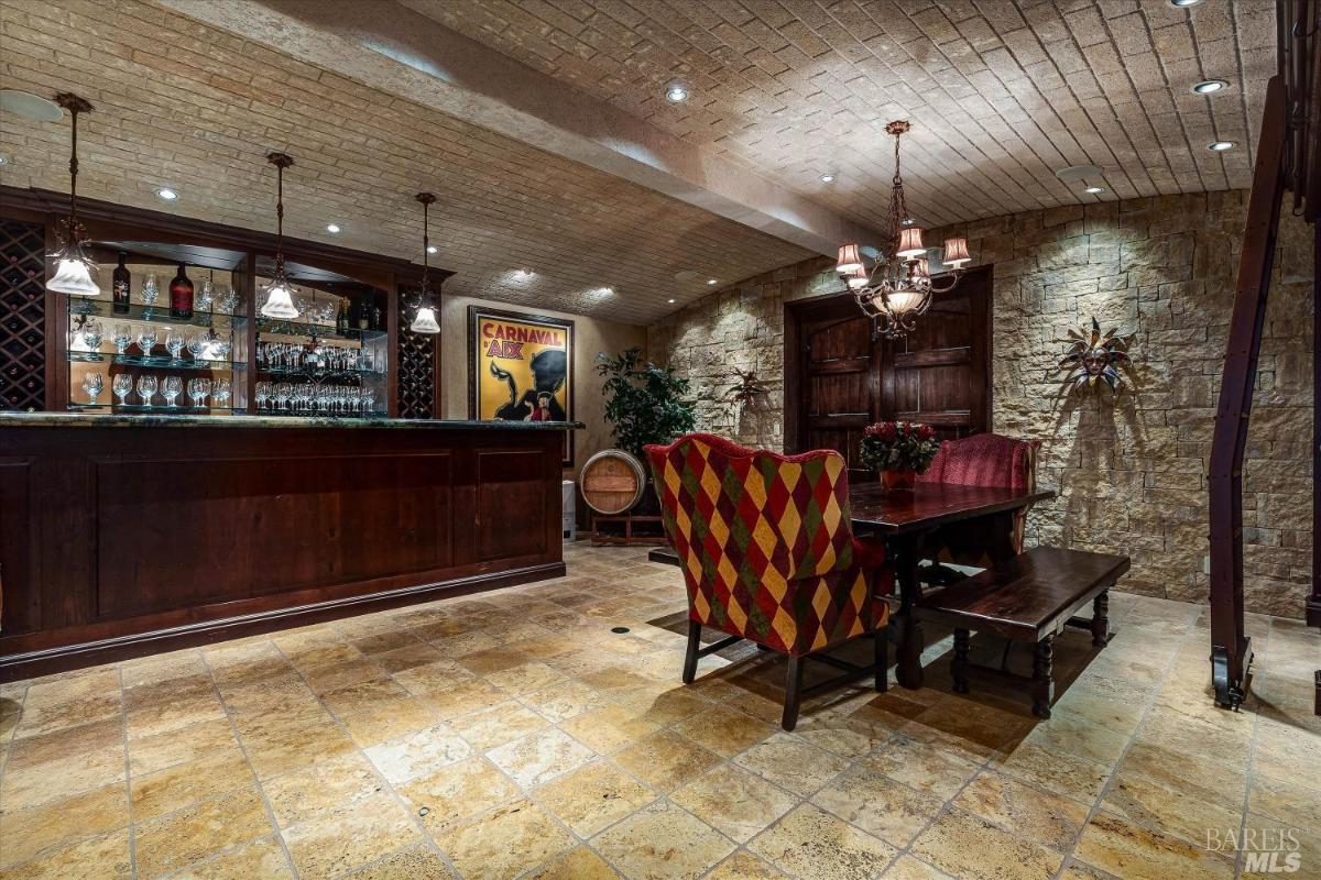 Wine cellar with a bar, a table, and brick accents.