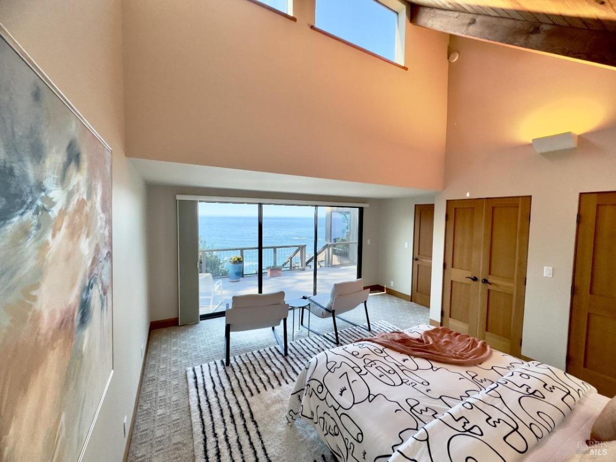 Bedroom with sliding doors leading to an ocean-facing balcony.