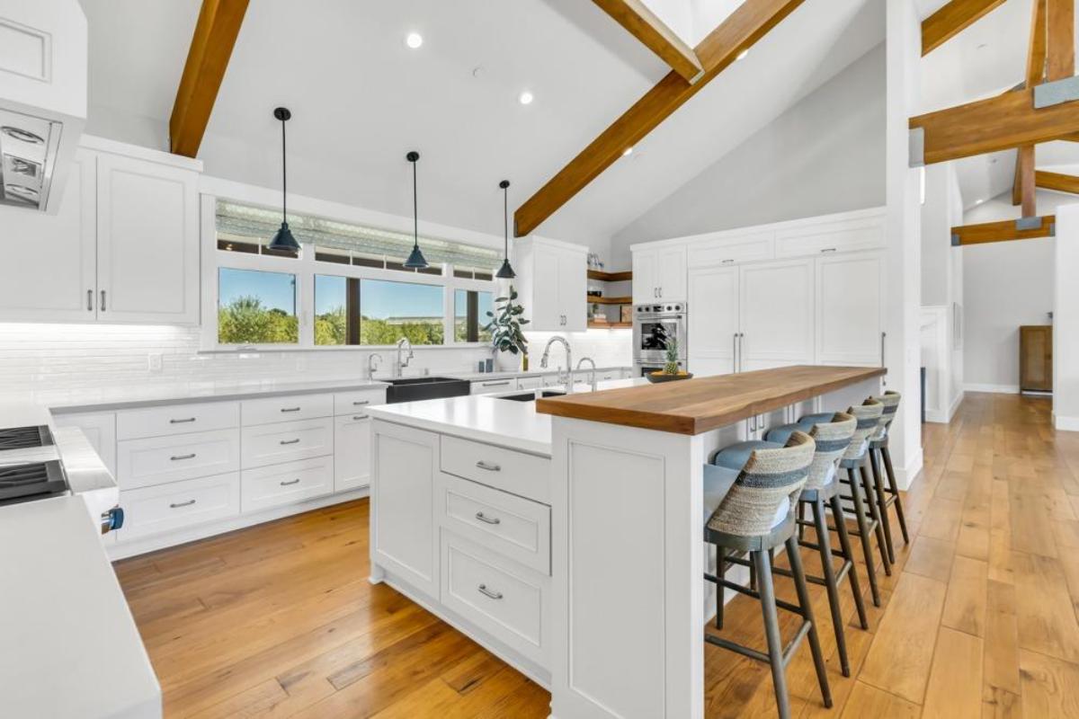 A kitchen featuring a bar with stools, countertops, and appliances.