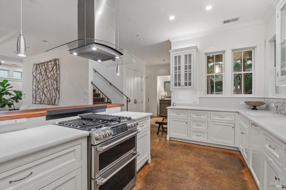 Kitchen with white cabinetry, a double oven, and stainless steel appliances.