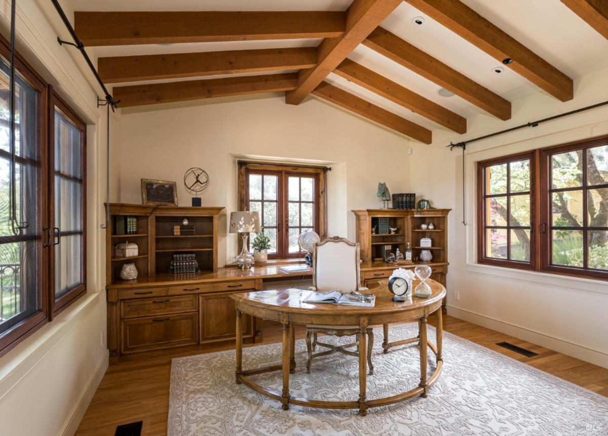 Office with wooden furniture and ceiling beams.