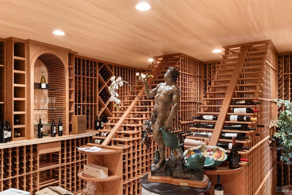 Custom-designed wine cellar with extensive shelving and a Bacchus statue centerpiece.