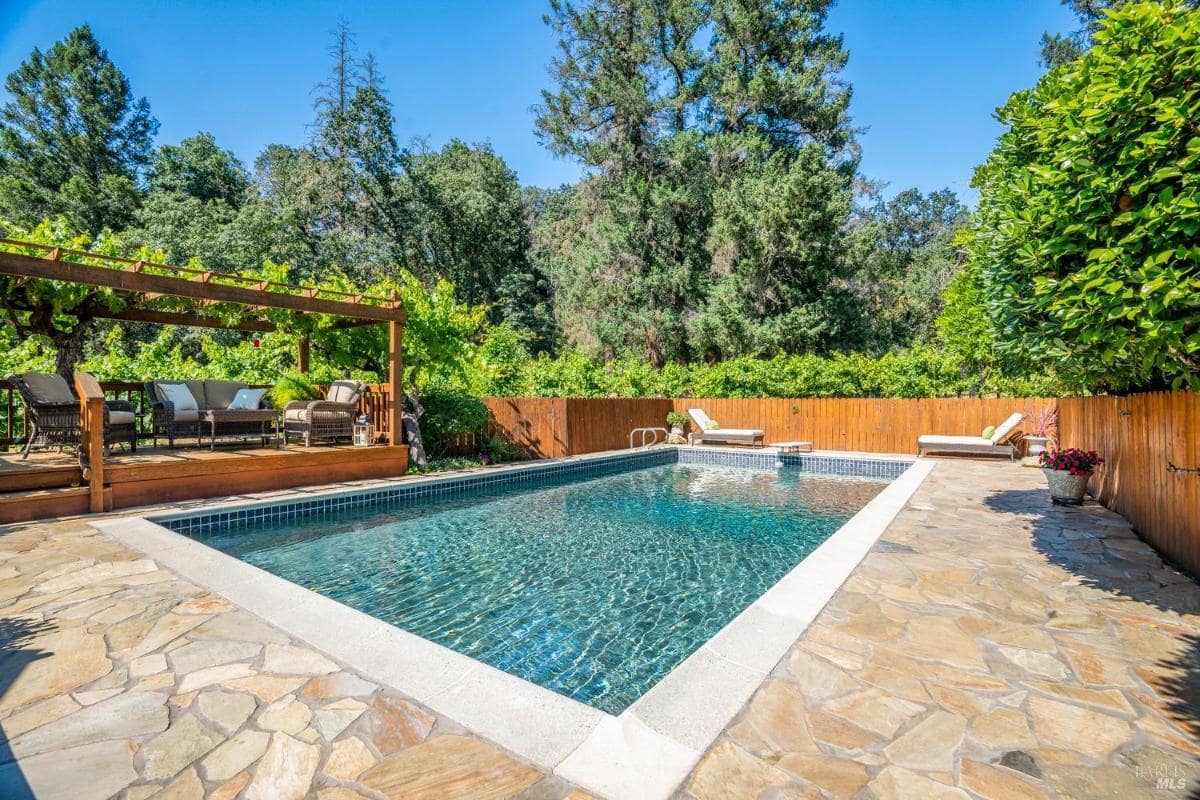 Pool area with stone paving and privacy fencing.