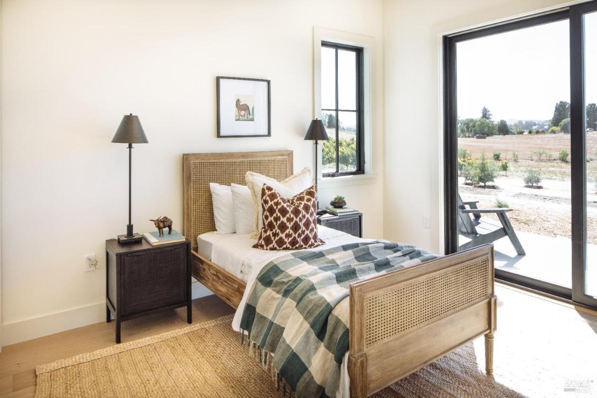 A bedroom with a single bed, nightstand, and sliding glass doors to an outdoor area.