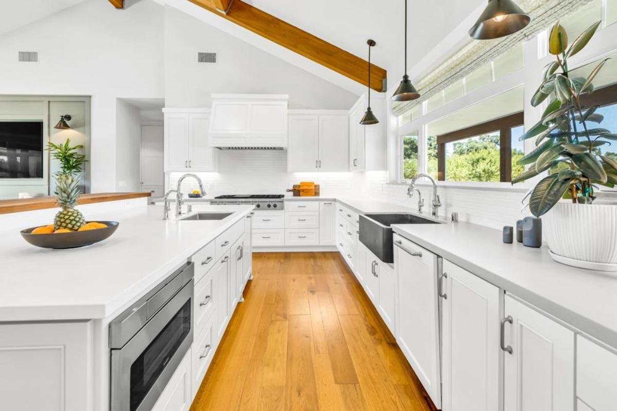 A kitchen featuring a bar with stools, countertops, and appliances.