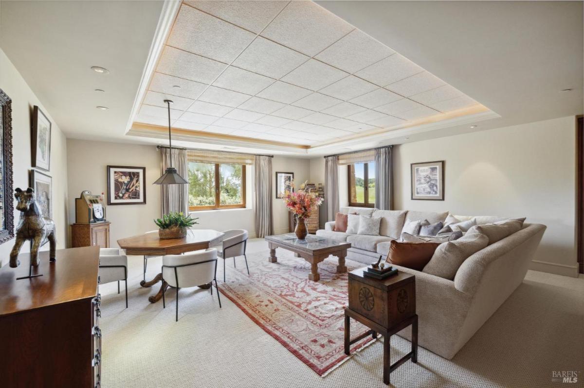 Living space with large sectional sofa, wooden coffee table, and adjacent dining area.