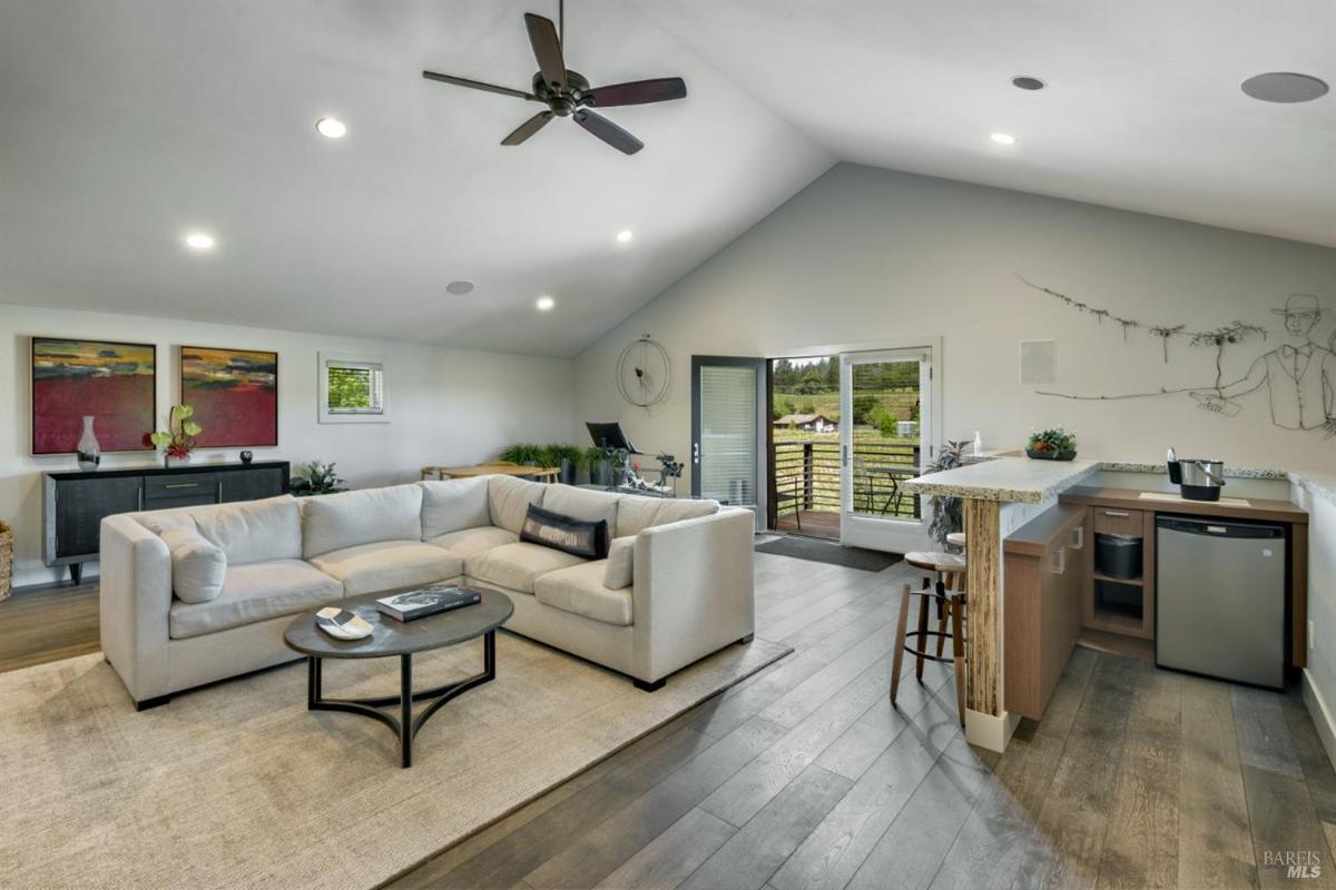 Rec room with a sectional sofa, bar counter, and outdoor access.