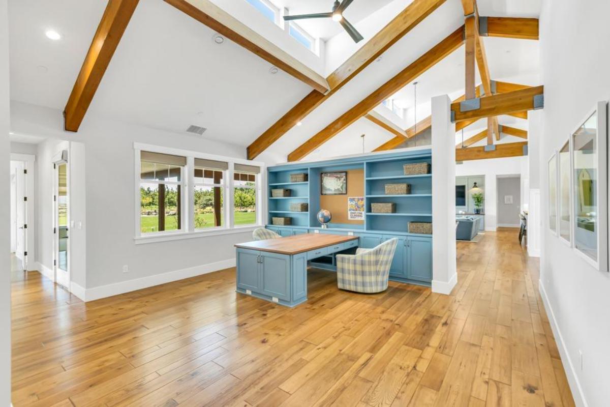 office area with a large desk, built-in shelves, and skylights.