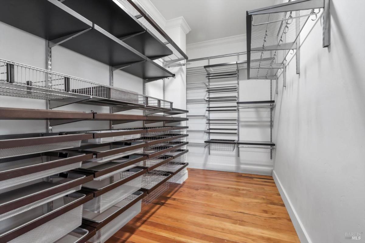 Organized pantry and racks with wooden flooring.