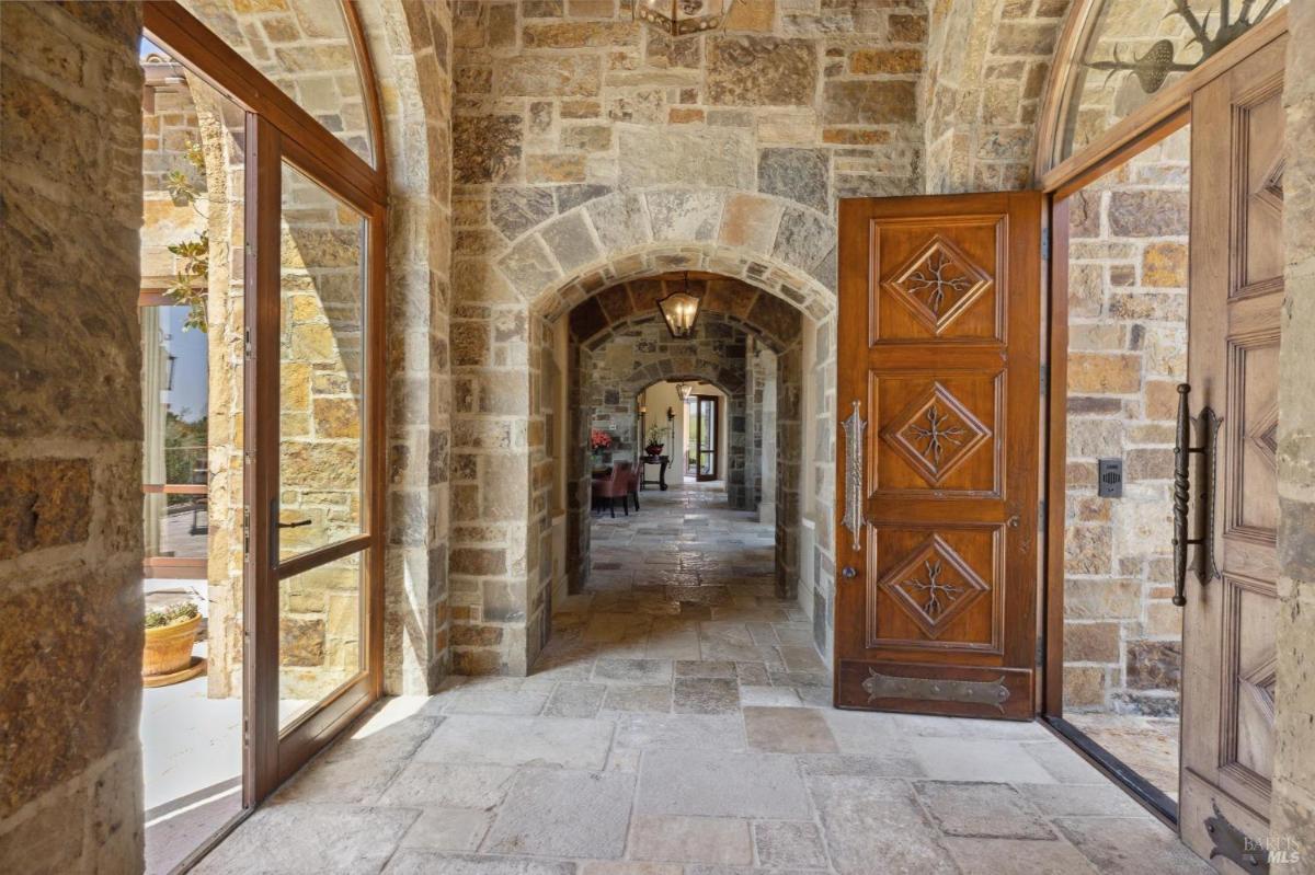 Hallway features a rustic design with wooden doors and a spacious, well-lit corridor.