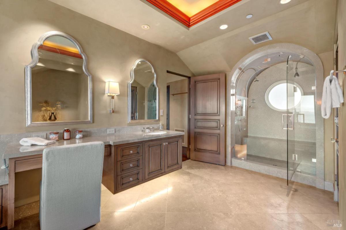 Bathroom featuring a double vanity with dark wooden cabinetry and a large mirror.