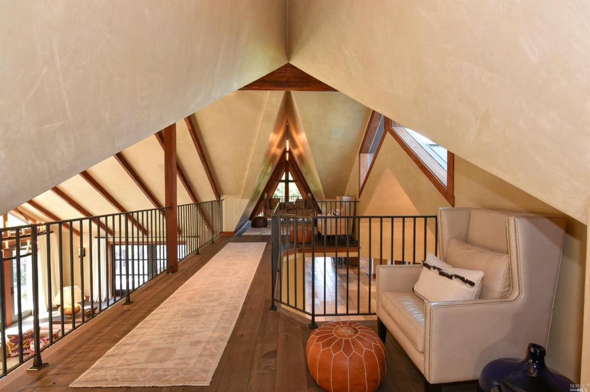 A loft space with railings, seating, and views of the main floor.