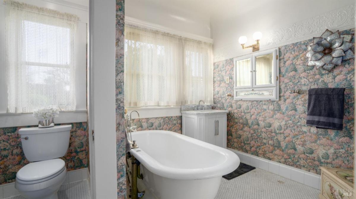 Bathroom with clawfoot tub, toilet, and vanity.