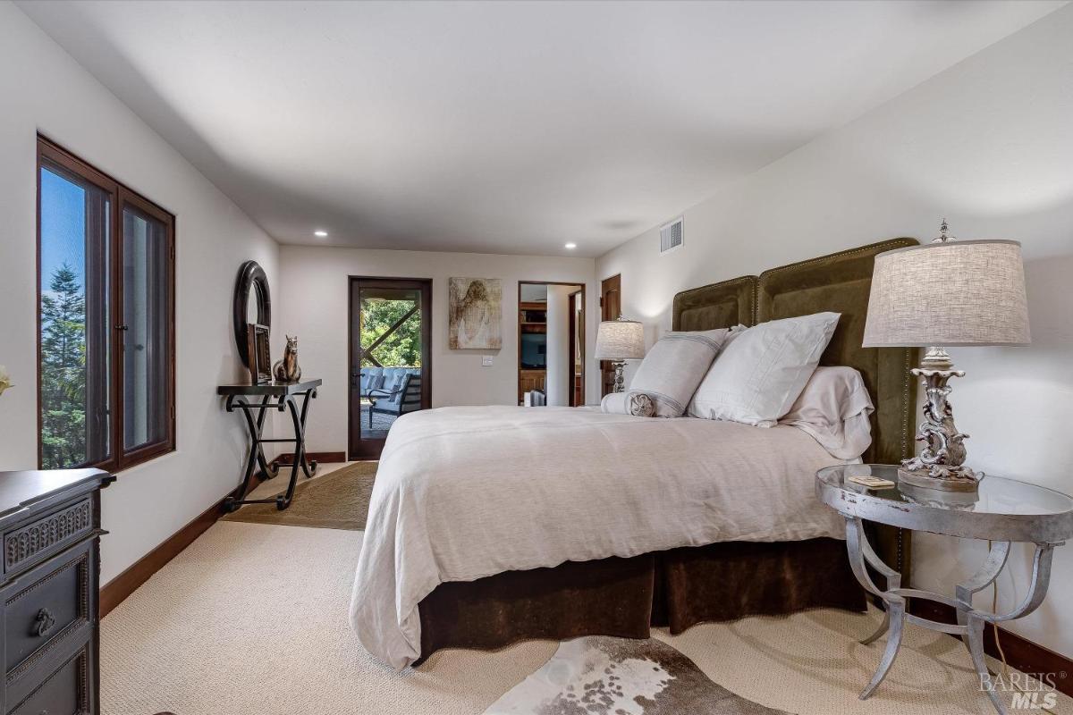 A bedroom with a bed, nightstands, and a door leading to a balcony.