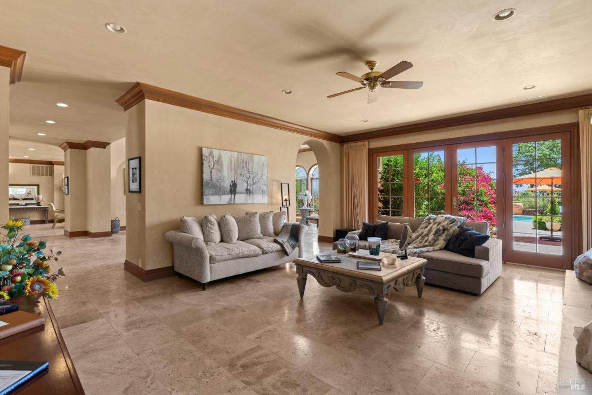 Family room with a stone fireplace, plush seating, and access to the patio.