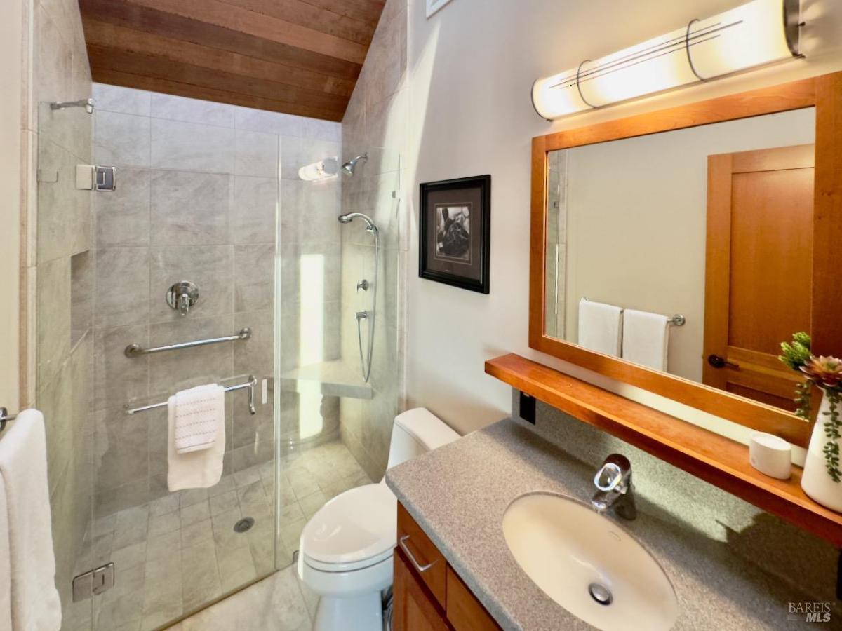 Another view of the same bathroom highlighting the glass shower and vanity area.