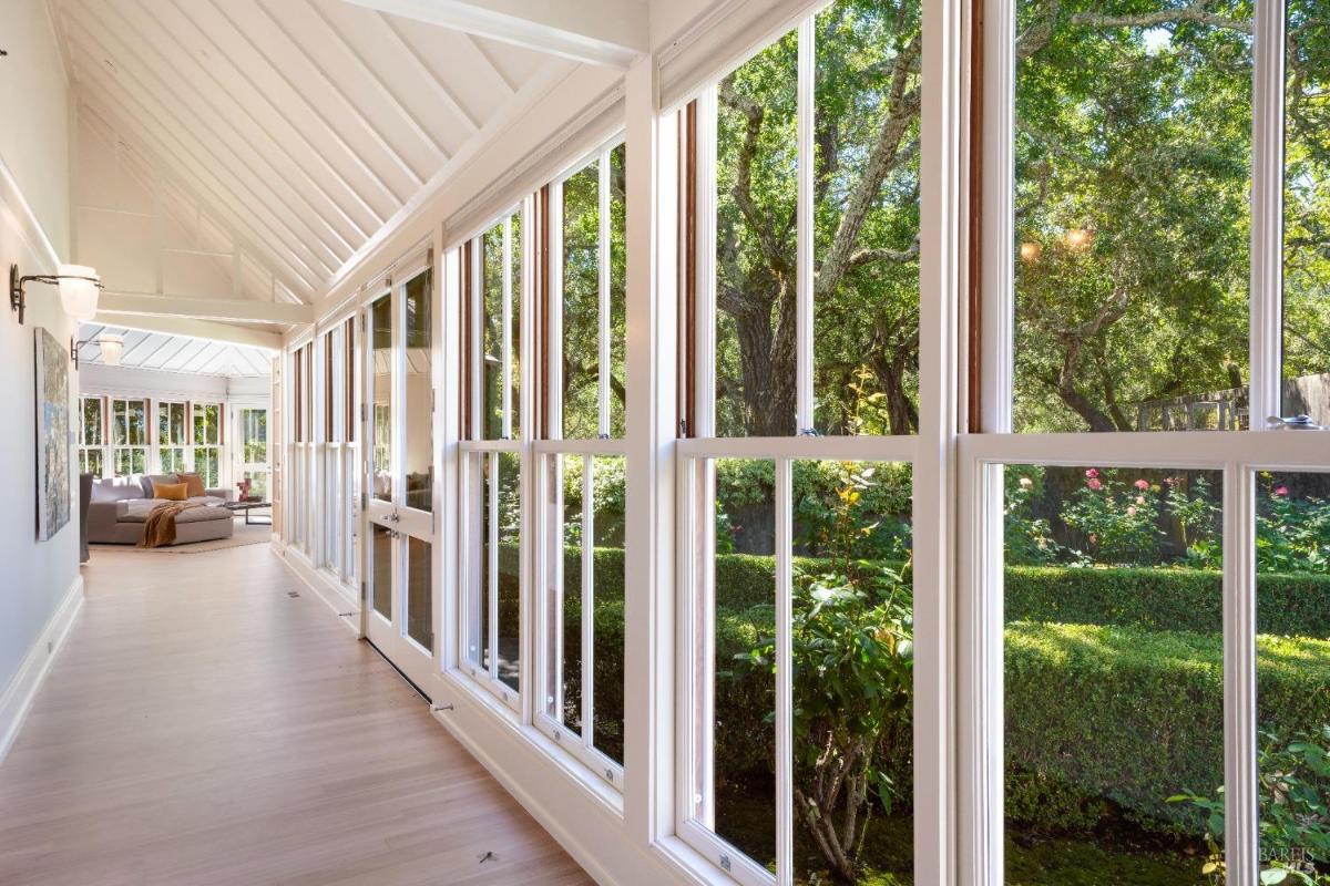 Hallway with large windows showing a landscaped garden.